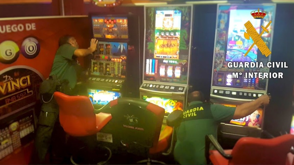 Agentes inspeccionan las tragaperras en el local.