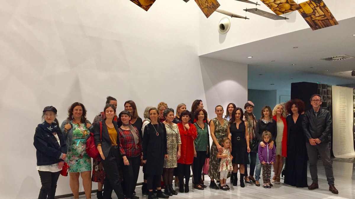 El grupo de artistas de la muestra posaban junto a las poetas y los organizadores.