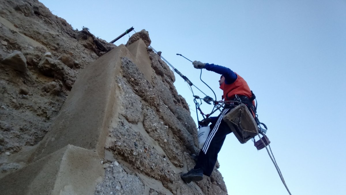 Uno de los obreros realiza labores de mantenimiento en un trozo de muralla aún visible.