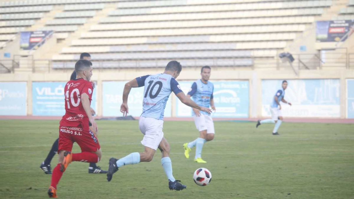 Carralero conduce el balón sobre el césped de Santo Domingo.