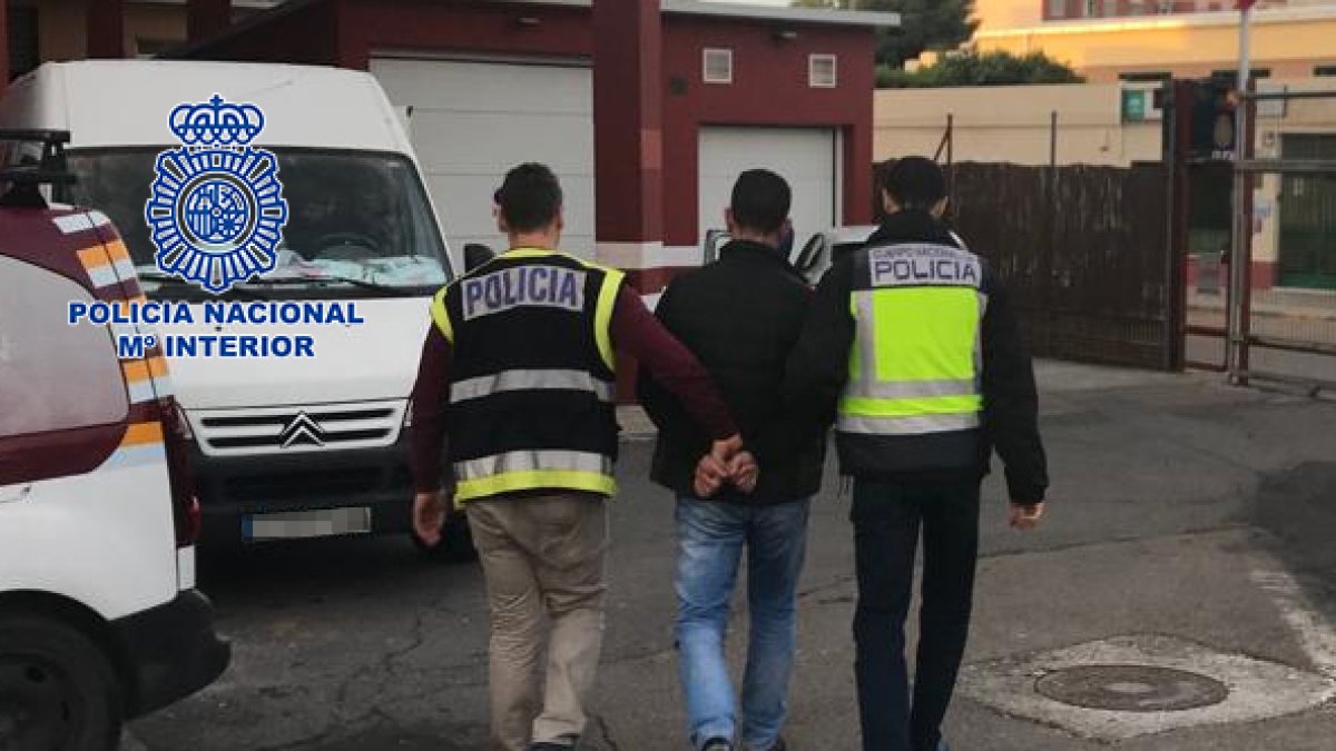 Dos policías nacionales llevan al detenido en El Ejido.