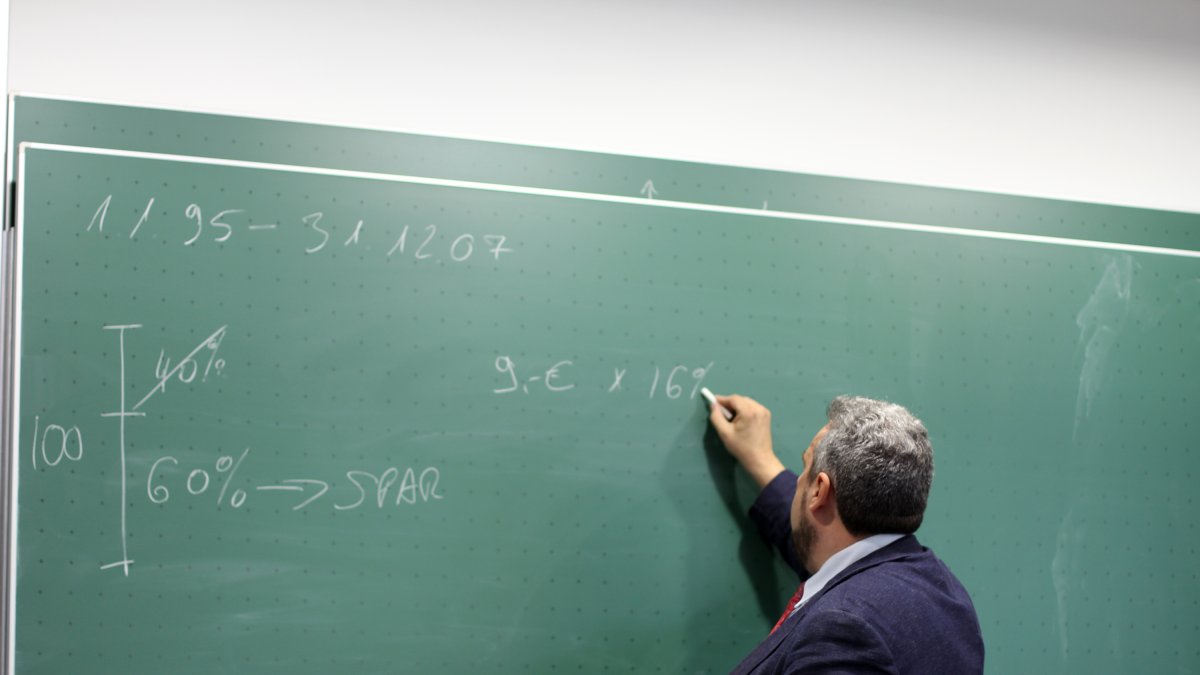 Un profesor en el momento que realiza una explicación en un aula.