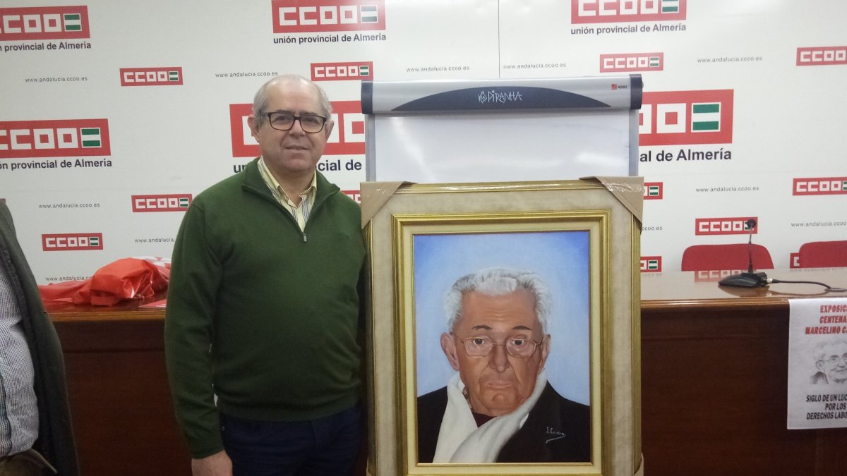 José Antonio Carrión junto al retrato que ha realizado de Marcelino Camacho.