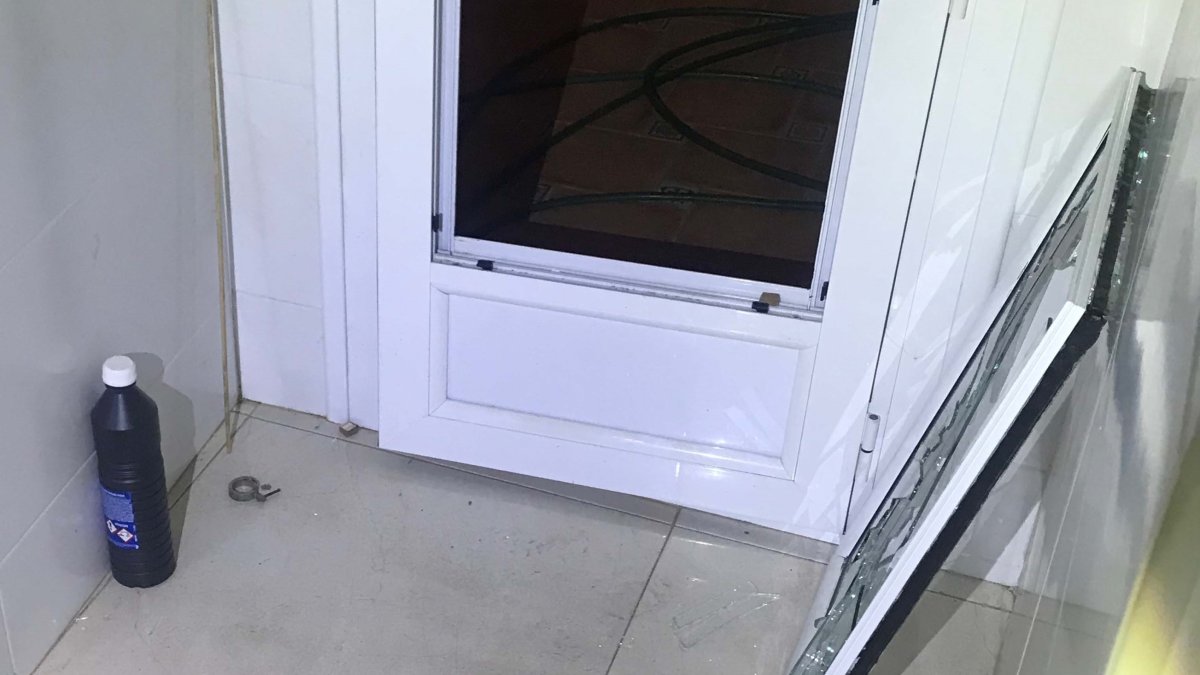 Imagen de la puerta de cristal dañada para acceder a la vivienda.