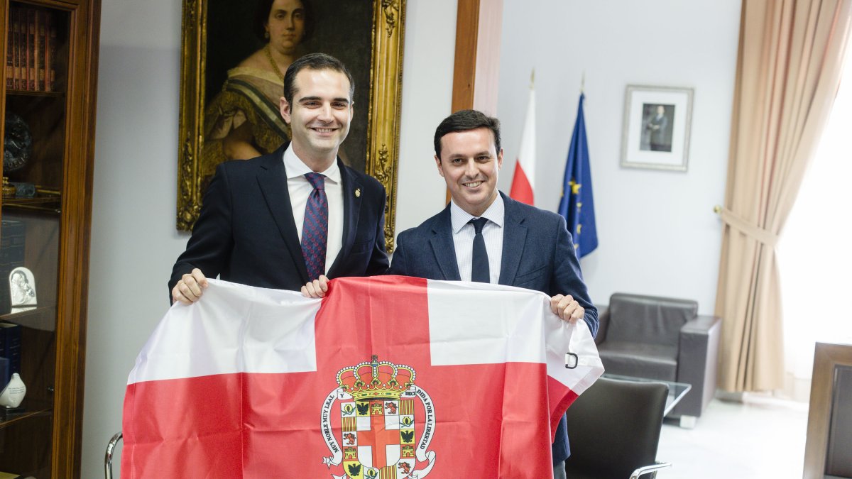 El alcalde le entrega la bandera de la ciudad al presidente de la Diputación.