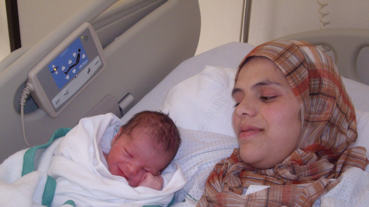 Una madre magrebí observa a su bebé recién nacido en el Hospital de Poniente