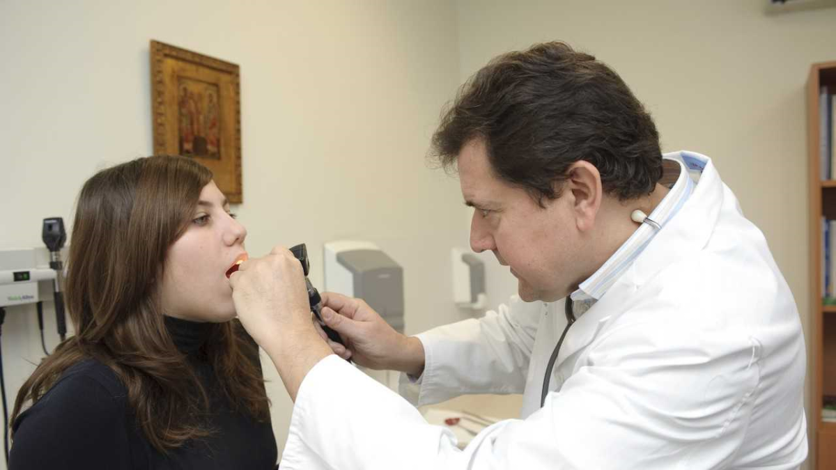 Un médico de familia examina a una joven paciente.