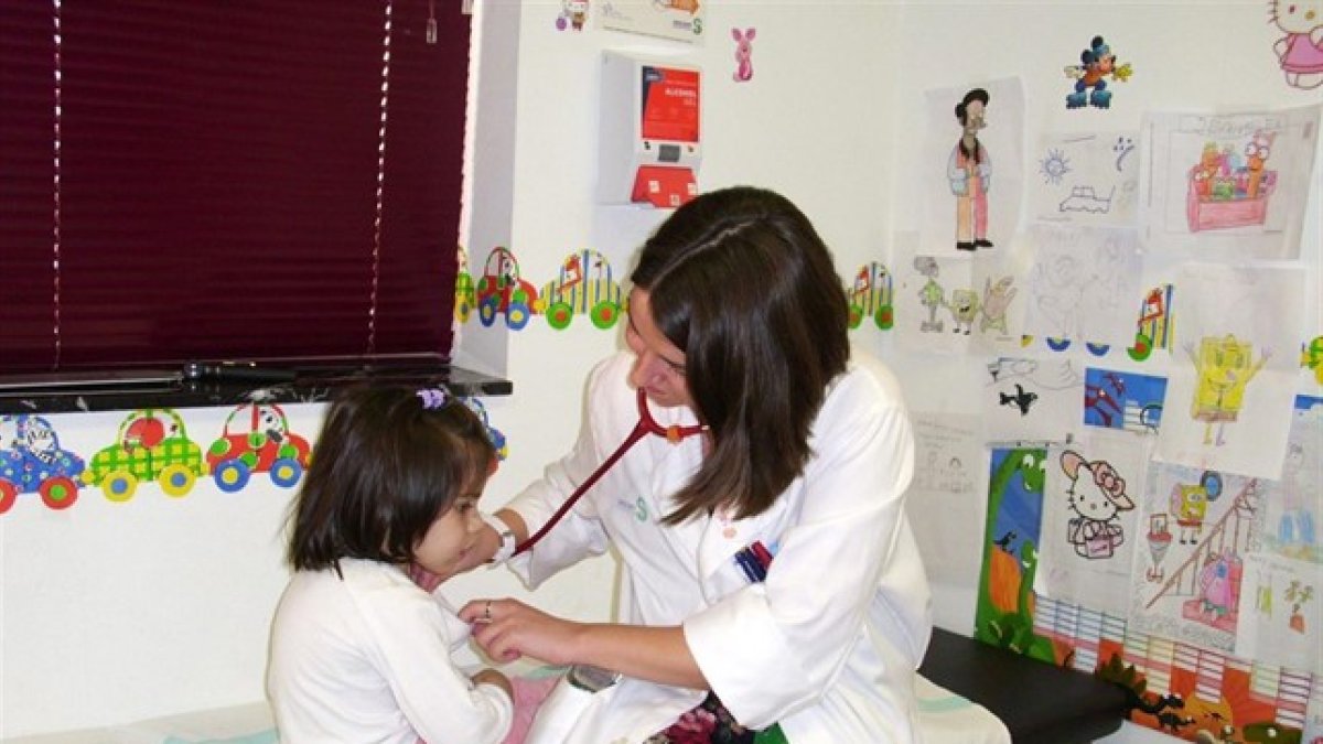 Una pediatra atiende a una niña.