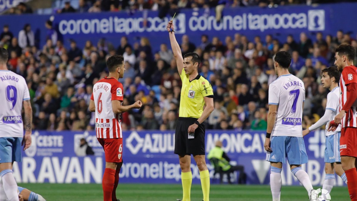 Varón Aceitón mostrando la cartulina amarilla.