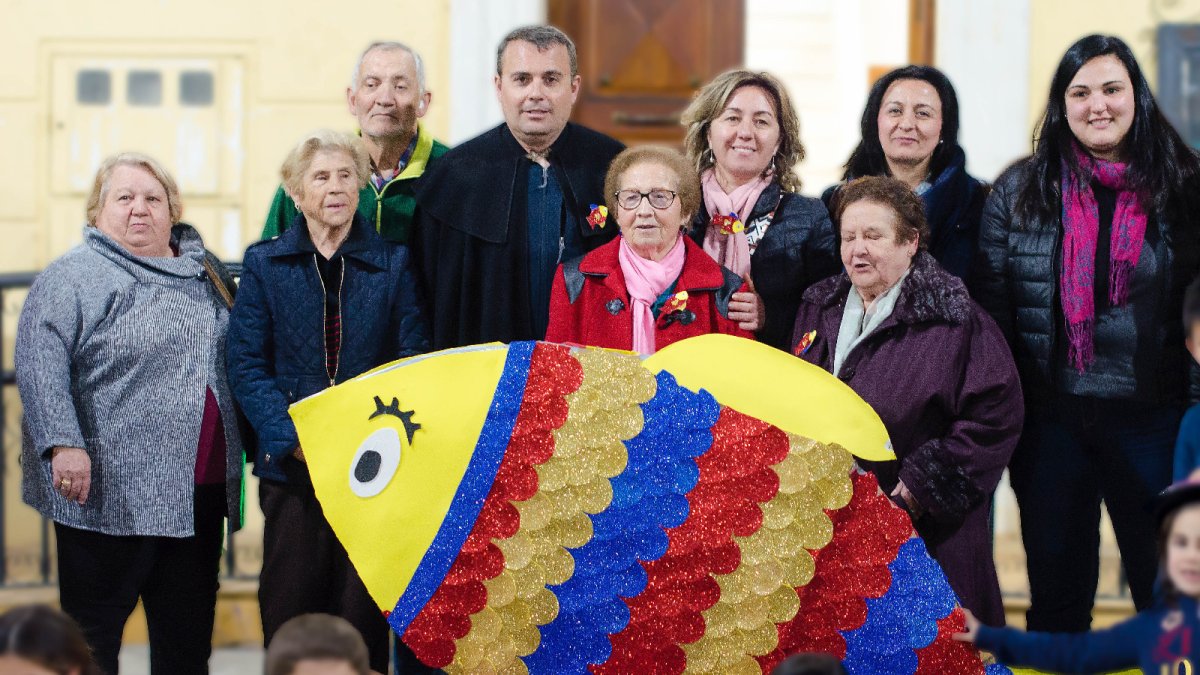 Los participantes en los talleres de envejecimiento con una de las sardinas elaboradas.