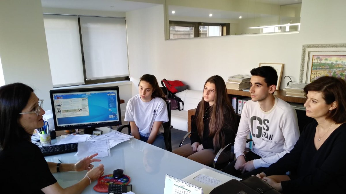 Los tres estudiantes y su profesora escuchan a la notario Marta Arrieta.