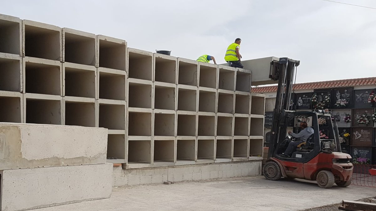 Operarios trabajando en la colocación de nuevos nichos en el cementerio.