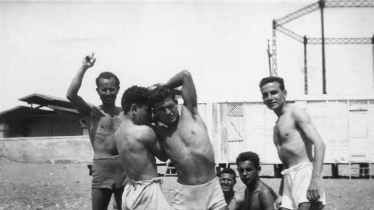 José Plaza , con la mano levantada, haciendo de juez en un combate de lucha en la playa.