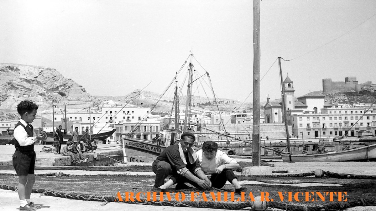 Un pescador mostrando los secretos de remendar las redes a unos paseantes en una mañana de domingo (Años 50).