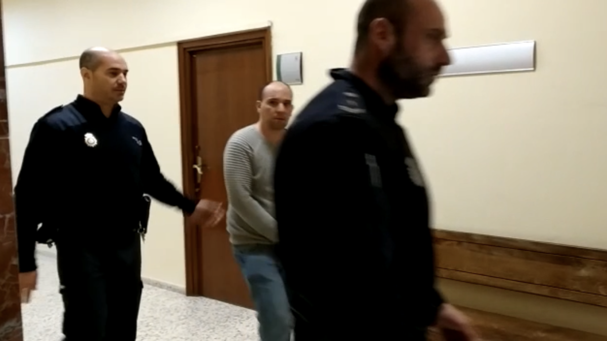 El condenado es conducido por dos agentes de la Policía Nacional durante las sesiones del juicio.