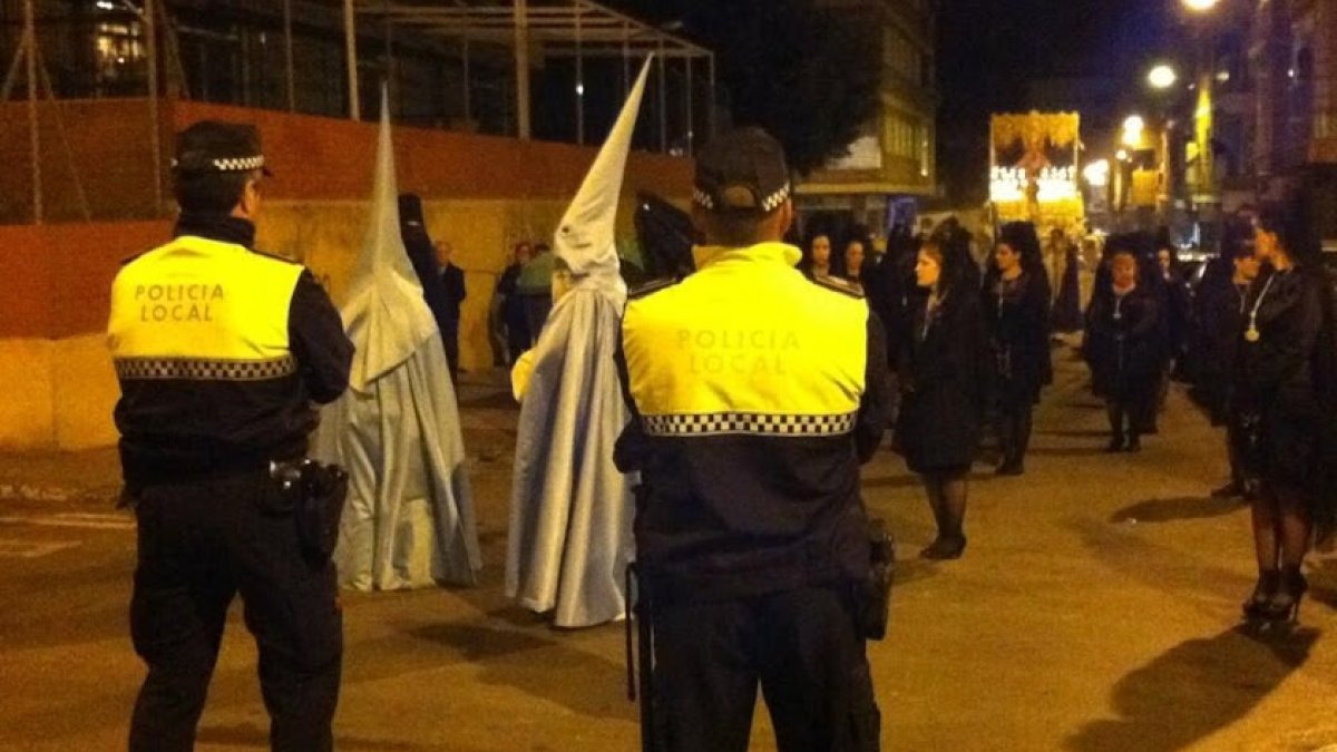 Dos policías locales, al paso de una procesión en Almería.