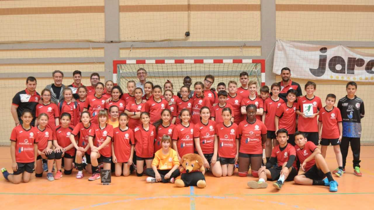 Los equipos masculino y femenino posan en la pist.