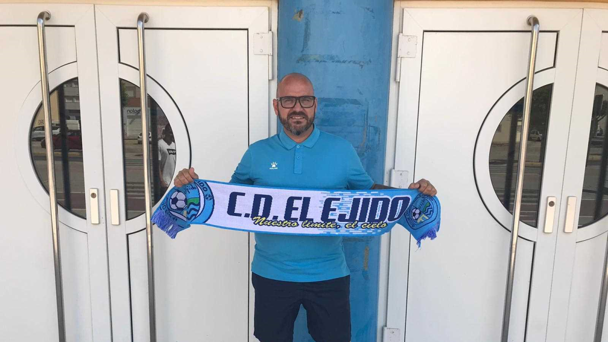 El nuevo entrenador con la bufanda celeste.