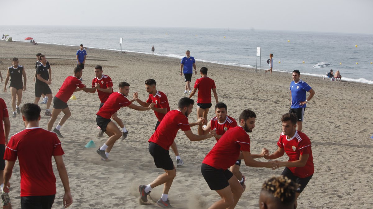 Los jugadores trabajando nen la arena ante la mirada de Óscar Fernández.