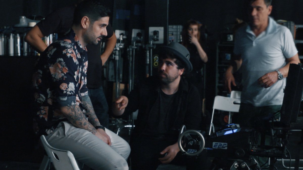 Willy Rodríguez conversa con el cantante Melendi durante la grabación de un videoclip del artista.