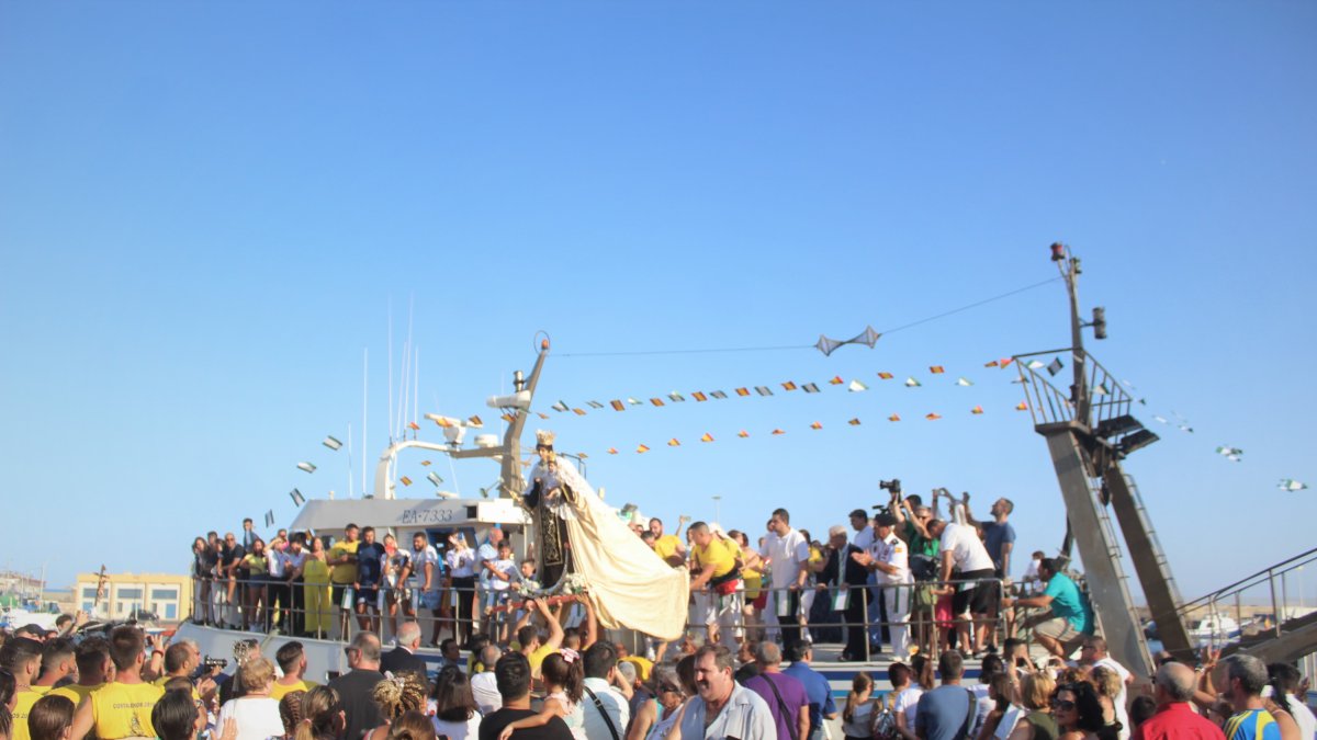 La Virgen del Carmen es subida al barco \'Mi Afriquita\' para iniciar la procesión marítima desde Pescadería.