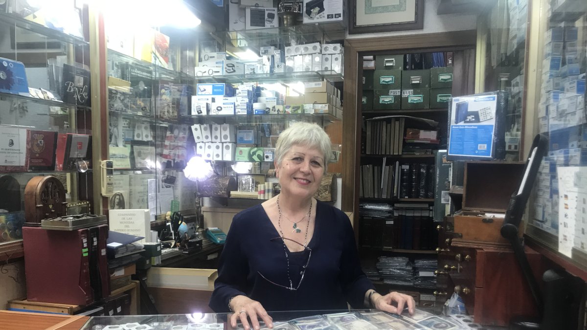 Doña María del Carmen, tras el mostrador de su pequeño negocio de filatelia y numismática situado en la calle de las Tiendas y abierto en el año 96.