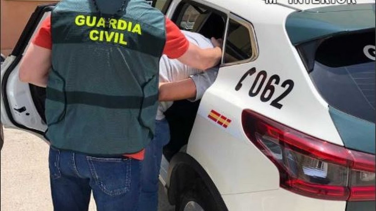 Imagen de un Guardia Civil con un detenido.