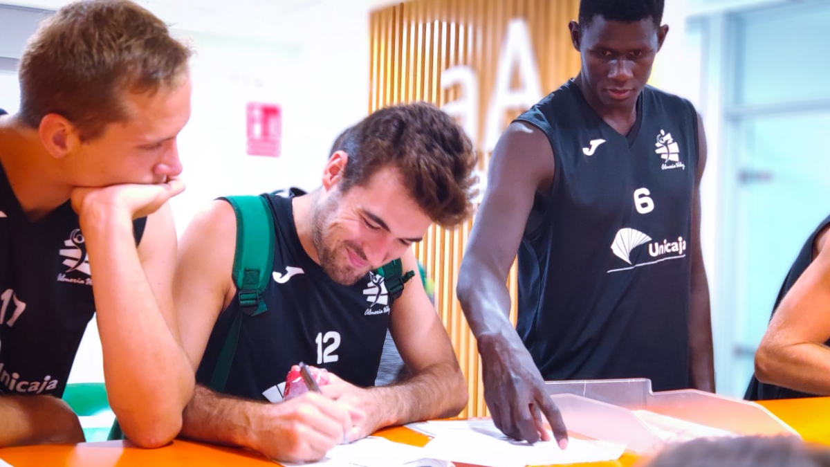 Los jugadores del Unicaja firmando.