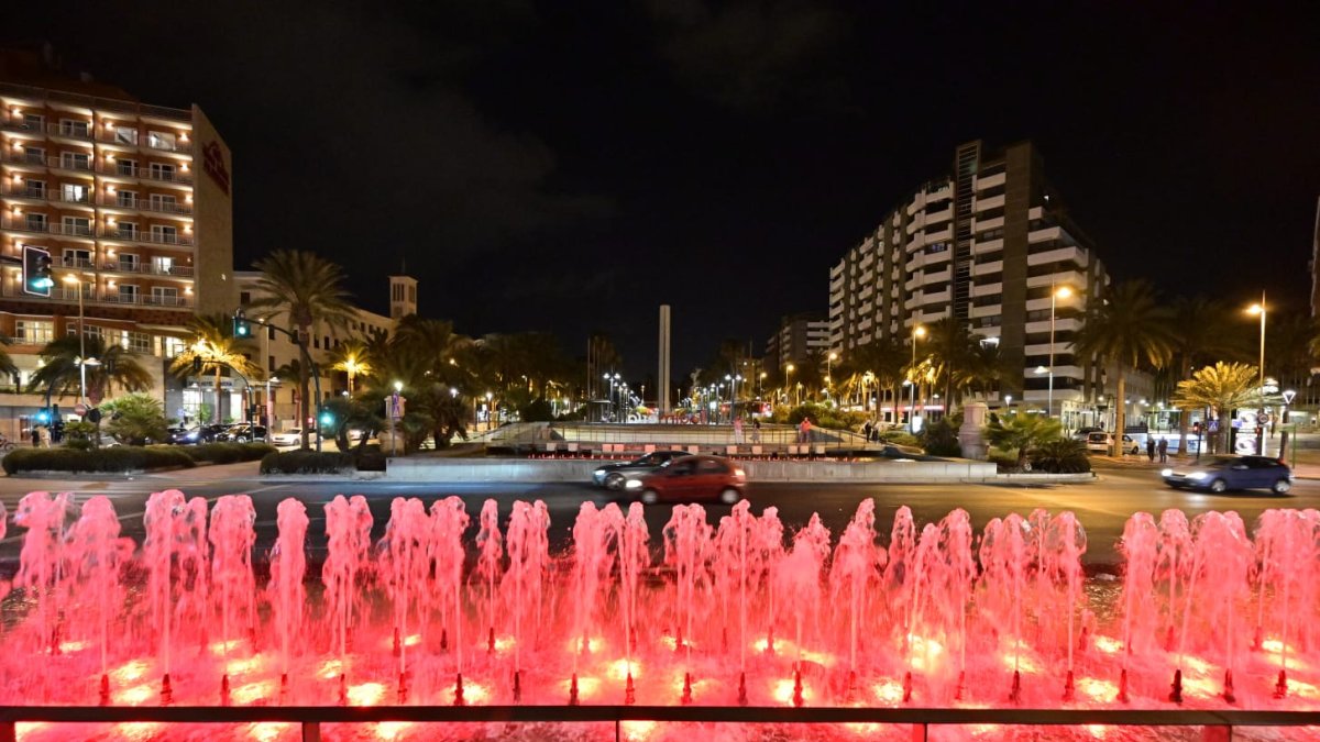 La fuente conocida como de los 103 Pueblos, al final de la Rambla, iluminada de rojo este sábado