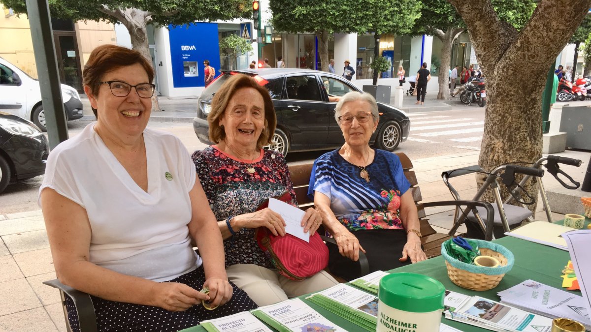 Esther Fernández, presidenta de la Amigos de Alzheimer (izq.), junto a dos voluntarias en la mesa informativa.