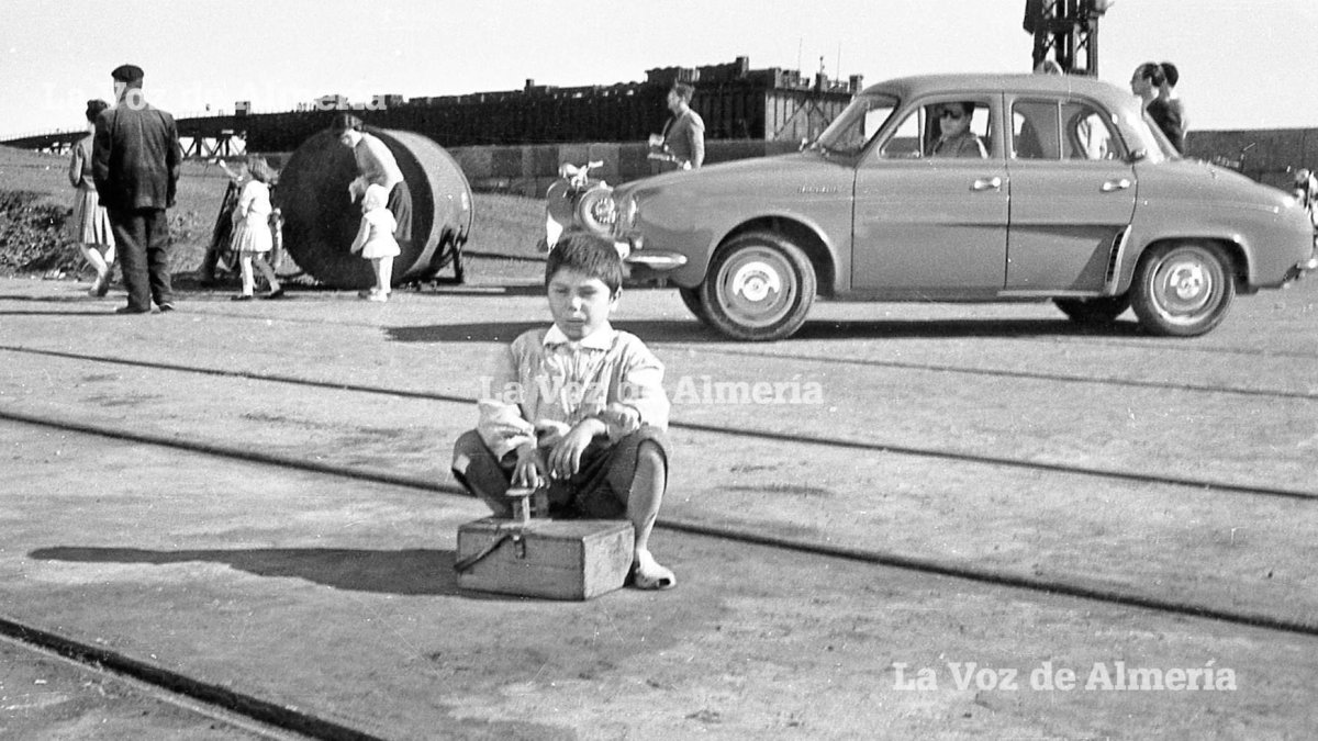 Un niño con la caja del cepillo y el betún, sentado en el muelle de levante a la espera de que le llegara un cliente. Eran los años sesenta.