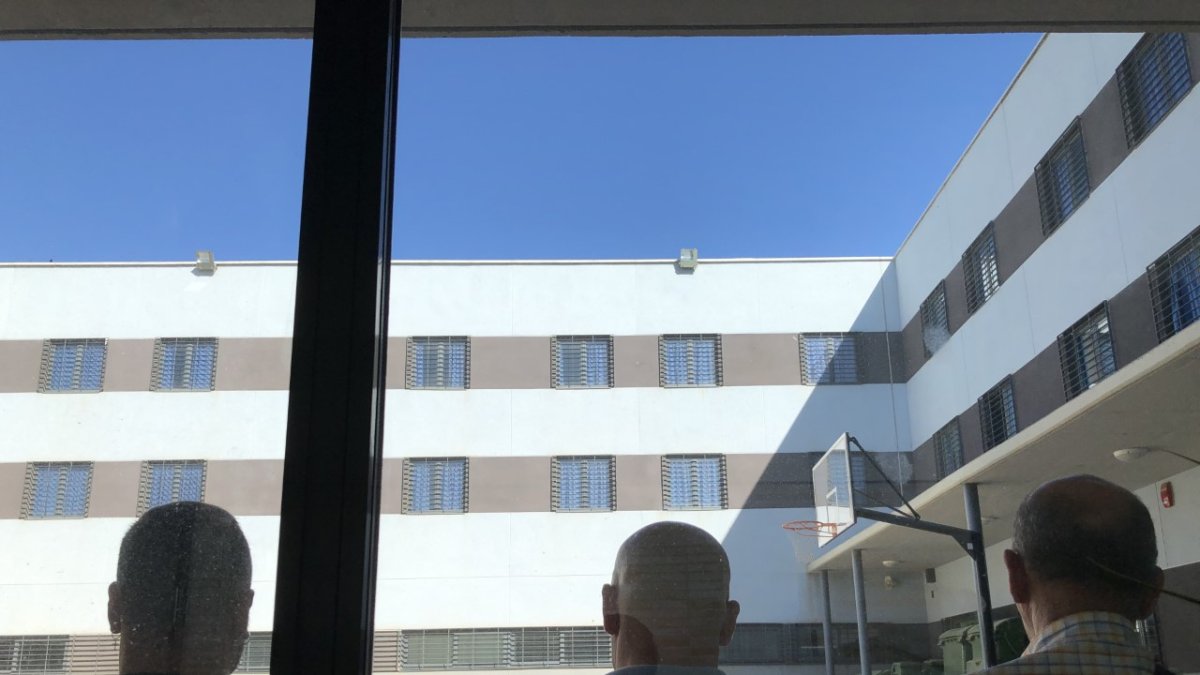 Tres internos miran las habitaciones desde el patio central del CIS este viernes