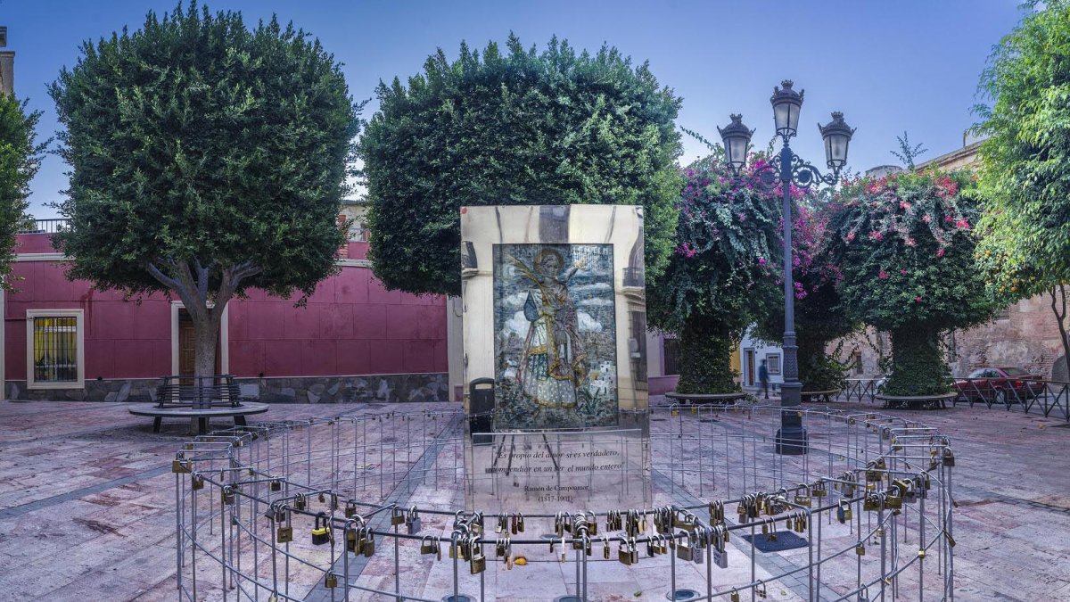 Plaza Campoamor con el bajorrelieve obra de Perceval y la valla llena de candados.