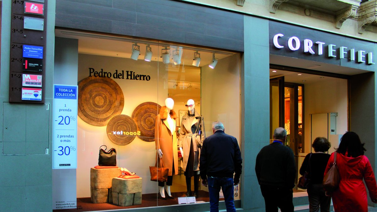 La ropa de abrigo aguarda a los clientes en los escaparates del Paseo, esperando las primeras noticias del invierno.