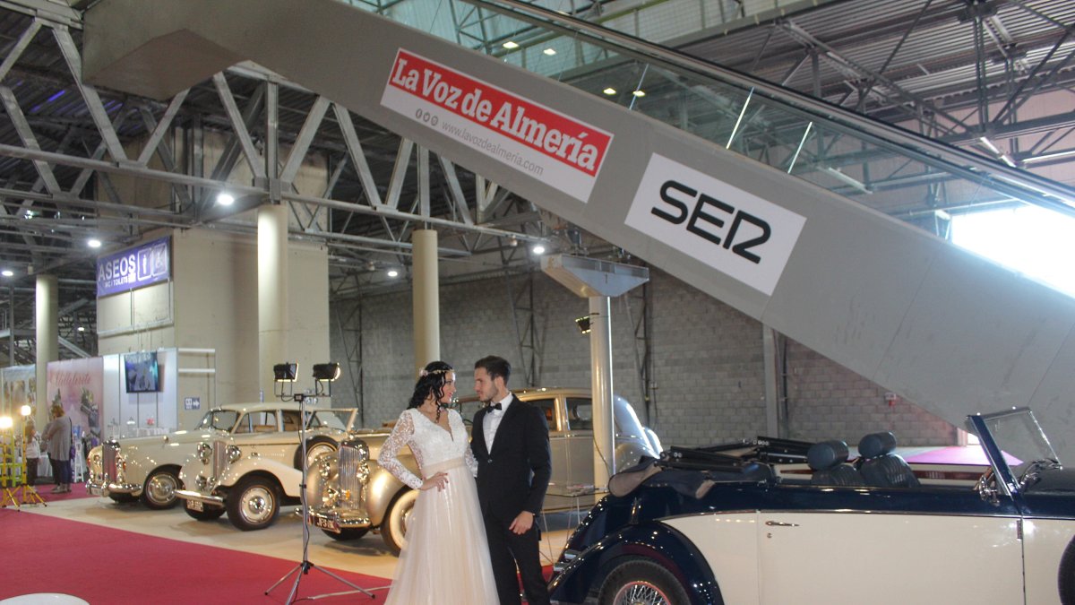 Novios ante vehículos clásicos en Expoboda.
