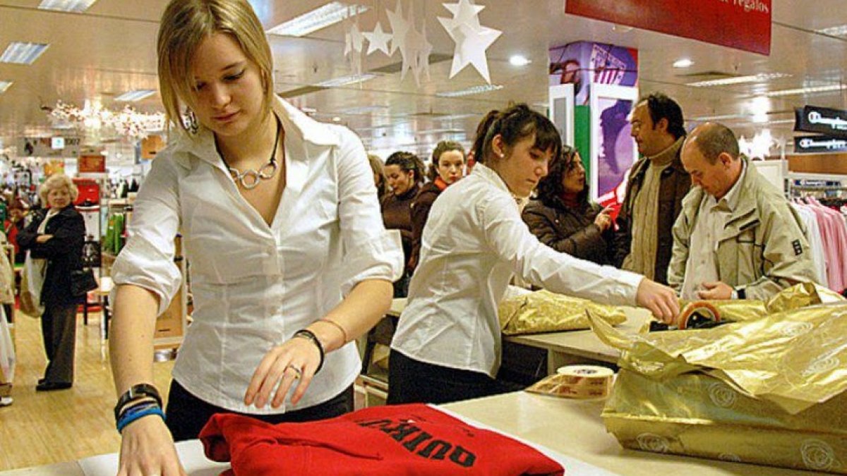 Dos dependientas doblan ropa en un establecimiento de la provincia.