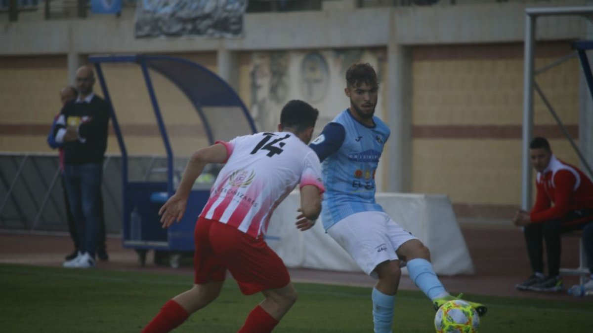 Dani conduce el balón junto a la banda de banquilos.