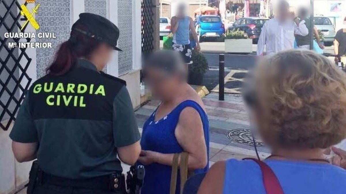 Una agente atiende a una mujer de avanzada edad.