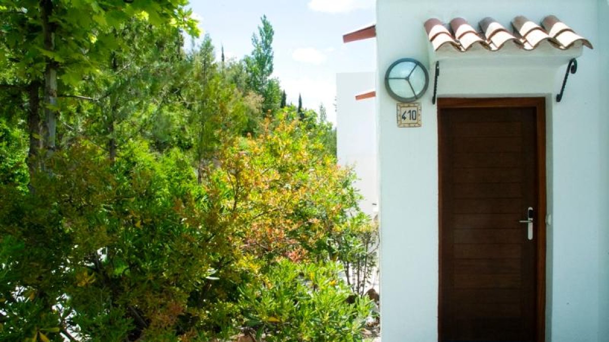 Las villas, de fachadas blancas y tejados rectos, se encuentran rodeadas de arbolado.