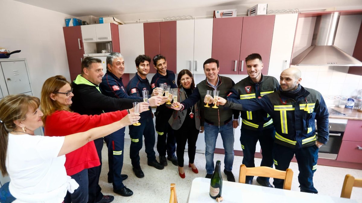 El prersidente de la diputación y la del consorcio brindan con los bomberos.