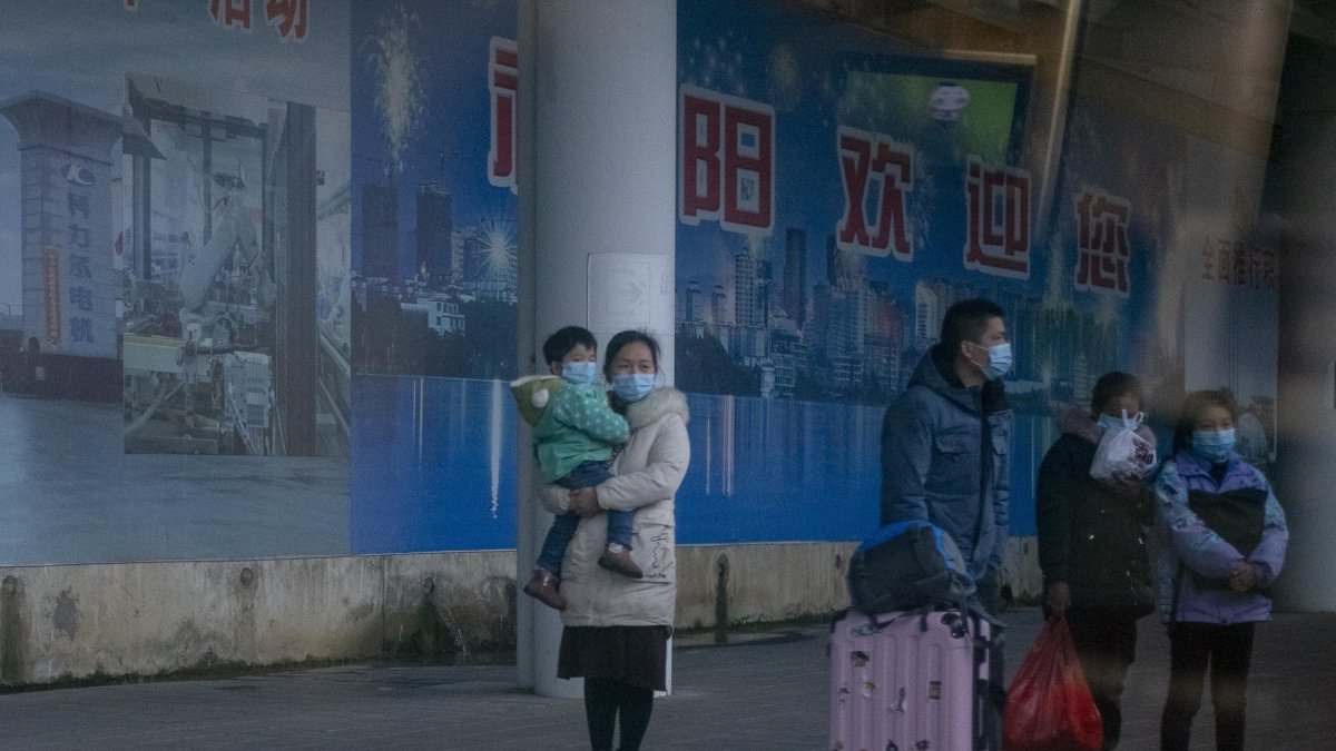 Una familia con una mascarilla en la estación de Nanning.