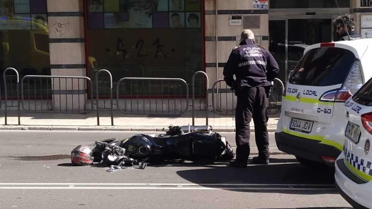 Un agente de Policía Local observa la moto tras el accidente.