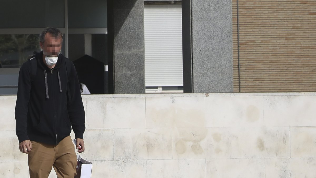 Un hombre con la mascarilla sin colocar sale del Hospital Universitario Virgen del Rocío.