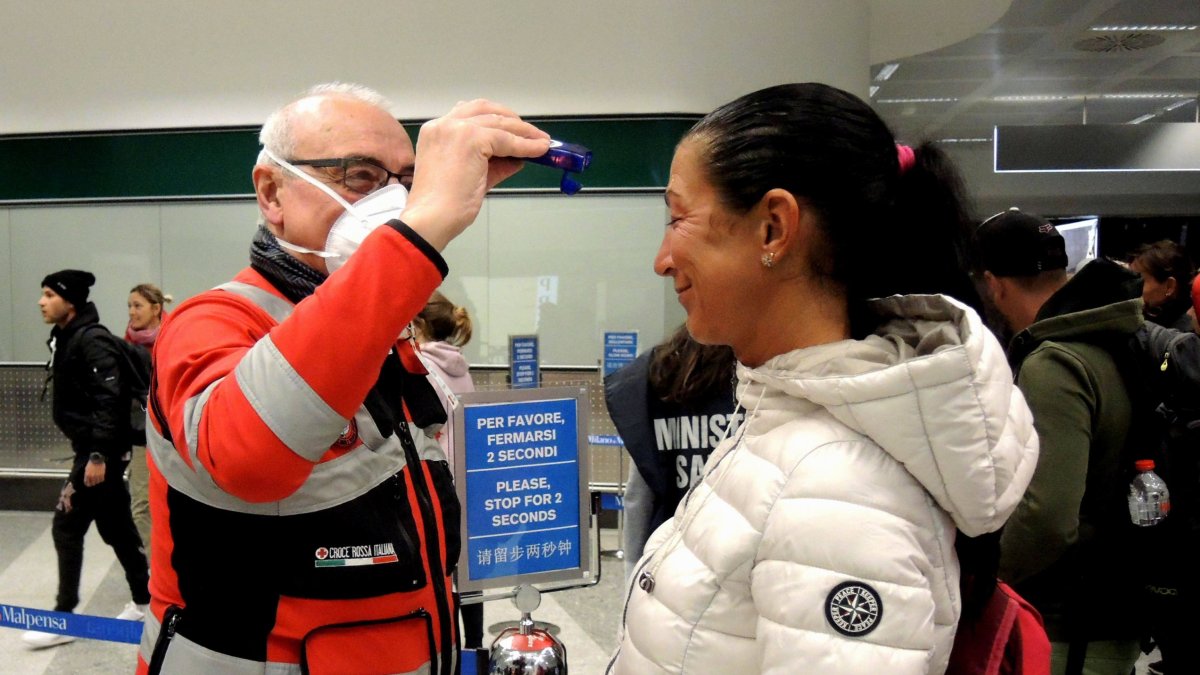Chequeo de temperatura a una pasajera en el aeropuerto de Milán.