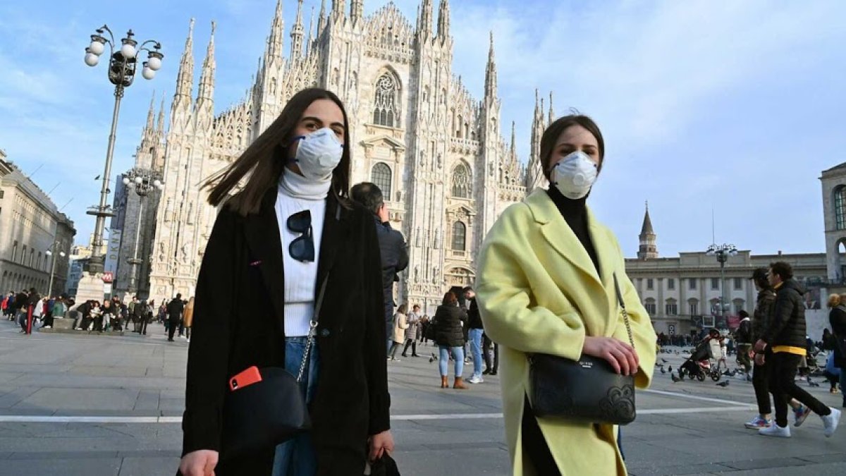 Dos jóvenes italianas con mascarilla en Milán.