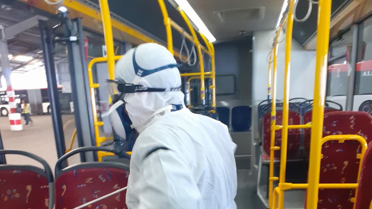 Trabajador desinfectando uno de los autobuses municipales