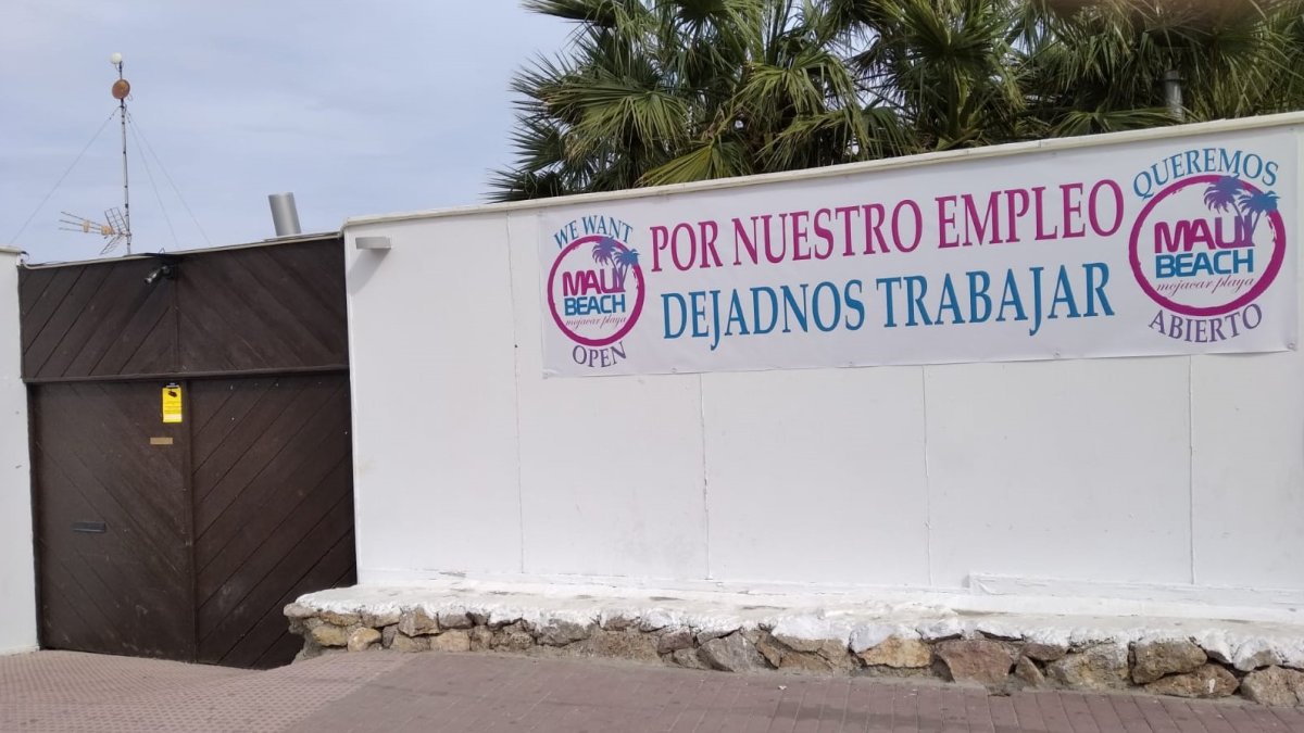 Cartel colocado por los trabajadores a la entrada del Maui, reclamando la reapertura del chiringuito.