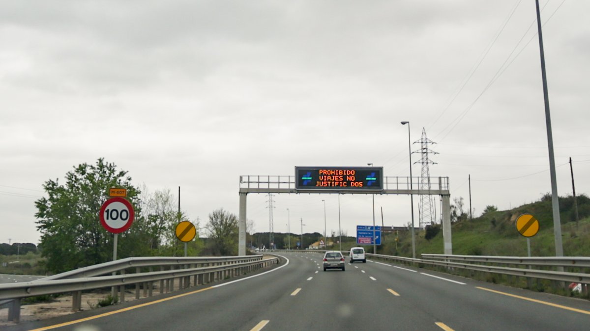 Cartel luminoso en una carretera en el que se lee: Prohibido viajes no justificados.