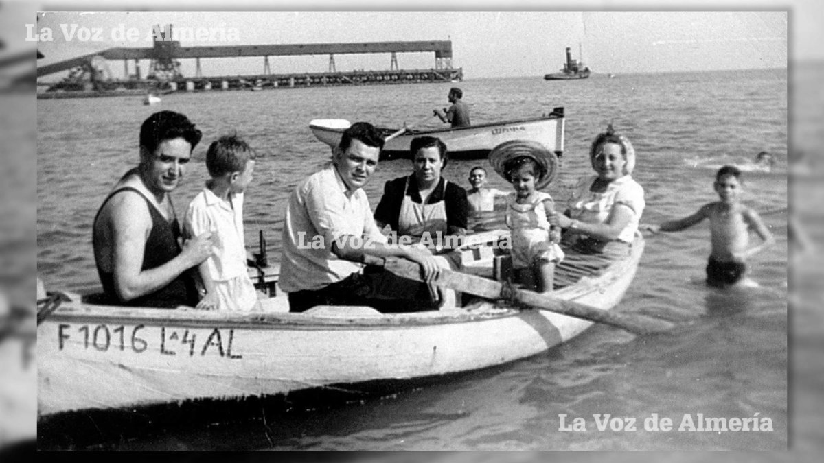 La querida familia del restaurante Imperial dando un paseo en barca por la playa de las Almadrabillas con el cargadero al fondo.