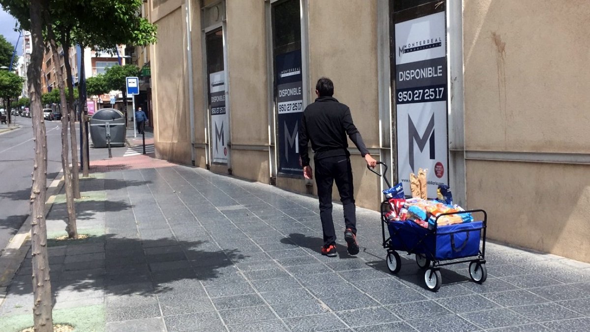 Un hombre con su avituallamiento de alimentos en un carro caminando ayer por la Avenida Pablo iglesias.